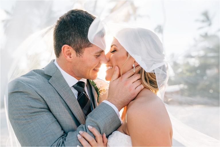 bride and groom kissing under veil