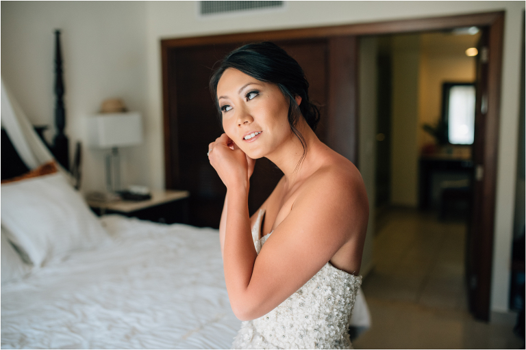 bride putting on jewelry