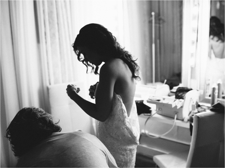 bride getting dressed for sunrise wedding